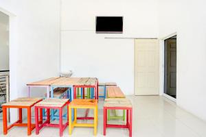 een groep kleurrijke tafels en stoelen in een kamer bij SUPER OYO 3702 Homestay Bougenville Syariah in Lamongan