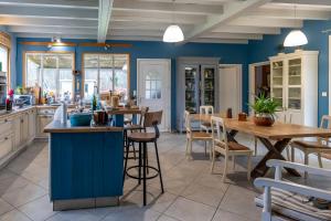 eine Küche mit blauen Wänden sowie einem Tisch und Stühlen in der Unterkunft les Cardaires in Grignols