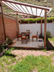 patio con tavolo e sedie sotto un padiglione di Casa Ymelda a Desaguadero