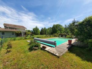 ein Schwimmbad in einem Hof neben einem Haus in der Unterkunft les Cardaires in Grignols