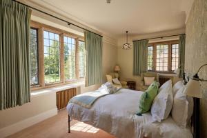 ein Schlafzimmer mit einem Bett in einem Zimmer mit Fenstern in der Unterkunft Rhodes House, Oxford in Oxford