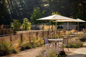 a table and chairs under an umbrella in a garden at Rhodes House, Oxford in Oxford