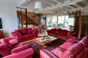 ein Wohnzimmer mit roten Sofas und einem Tisch in der Unterkunft les Cardaires in Grignols