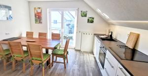 une cuisine et une salle à manger avec une table et des chaises dans l'établissement BodenSEE Apartment Tettnang HOPFENTRAUM, à Tettnang