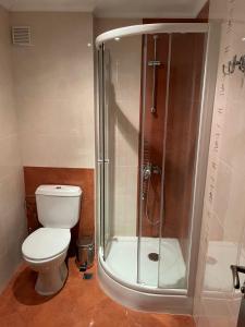 a bathroom with a toilet and a glass shower at Kalaidjievi in Bansko