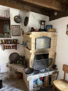 a living room with a brick fireplace with a tv at Kalaidjievi in Bansko