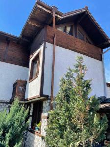 a house with a tree in front of it at Kalaidjievi in Bansko