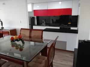 a kitchen with a glass table and red cabinets at descanso los ANDES in Duitama