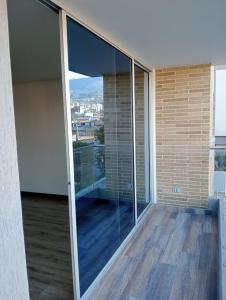 a balcony with glass doors and a view of a city at descanso los ANDES in Duitama