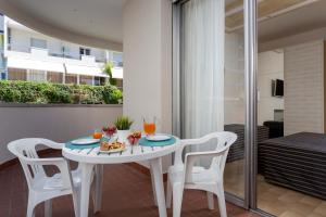 un piccolo tavolo bianco e sedie su un balcone di Residenza Levante a Riccione