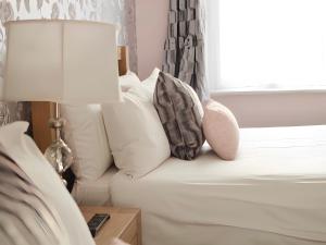 a bedroom with a bed with pillows and a lamp at The Star Hotel in Southampton