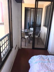 um quarto com uma varanda com uma mesa e cadeiras em Arriendo Departamento em Santiago