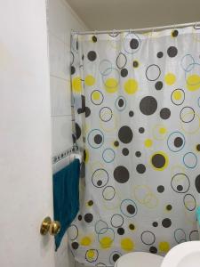 uma cortina de chuveiro com um padrão de bolinhas na casa de banho em Arriendo Departamento em Santiago