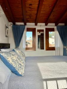 1 dormitorio con 1 cama con cortinas azules en Porto Valentino Apartment, en Sirmione