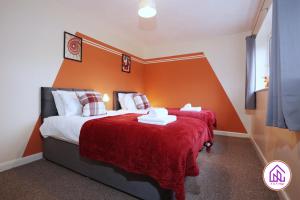 two beds in a room with orange walls at Blagdon Park, Stylish house in Bath, Free parking in Bath