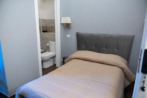 um pequeno quarto com uma cama e um WC em B&B Palazzo Fischetti em Catânia