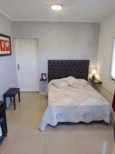 een slaapkamer met een groot bed met een zwart hoofdeinde bij Apartamentos Anahí in Villa Parque Siquiman