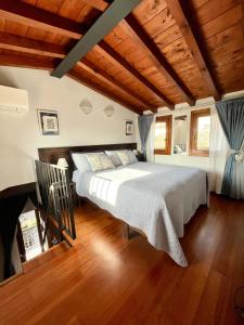 Un dormitorio con una cama grande en una habitación con techos de madera. en Porto Valentino Apartment, en Sirmione