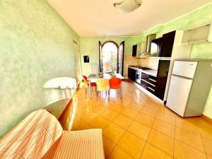 eine Küche mit Tisch, Stühlen und Kühlschrank in der Unterkunft Sole Trilo - a 100 m dal mare e dal centro di Marcelli in Marcelli