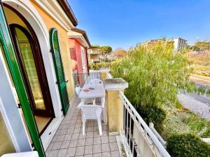 ein Balkon mit Tisch und Stühlen an einem Haus in der Unterkunft Sole Trilo - a 100 m dal mare e dal centro di Marcelli in Marcelli
