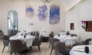a dining room with white tables and chairs at Aminess Younique Korcula Heritage Hotel in Korčula