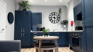 a kitchen with blue cabinets and a table at Studio On The Rows - Central City Centre in Chester