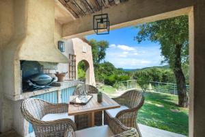 patio con mesa, sillas y horno al aire libre en Villa Quercia, en Fréjus