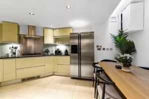 uma cozinha com uma mesa e um frigorífico de aço inoxidável em Piccadilly House em Londres