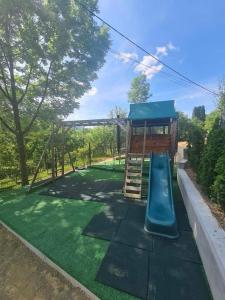 un parque infantil con un tobogán en un patio en Pensiunea Daniela en Moisei