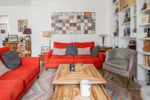 salon z czerwonymi kanapami i stolikiem kawowym w obiekcie Spacious apartment with balcony in Paris - Welkeys w Paryżu