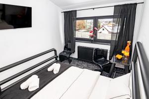 a bedroom with a bed with white pillows and a window at Golden Lion House Bed&Breakfast in Rumia