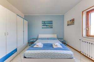 ein blau-weißes Schlafzimmer mit einem Bett und einem Fenster in der Unterkunft Appartamento climatizzato con vista mare a 50 m dalla spiaggia in Lido Marini