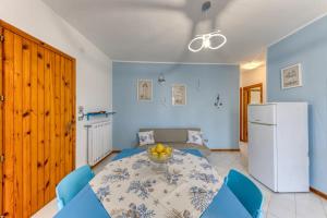 ein Wohnzimmer mit einem Tisch und einem Kühlschrank in der Unterkunft Appartamento climatizzato con vista mare a 50 m dalla spiaggia in Lido Marini