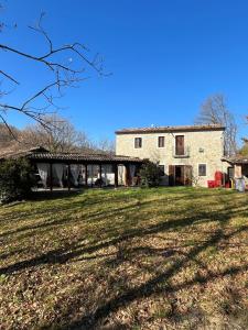 une grande maison avec une pelouse devant elle dans l'établissement Casale Cipriani, 