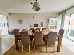 a dining room with a wooden table and chairs at La Villa Camael in Le Tampon