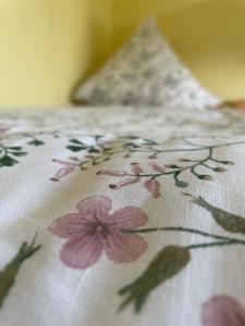 a bed with a white blanket with flowers on it at Moderne Zimmer im Grünen, mit Park- und Meer-Nähe in Bad Zwischenahn