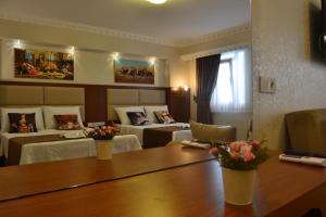 イスタンブールにあるブルー イスタンブール ホテル タクシムのベッドと花のテーブルが備わるホテルルームです。