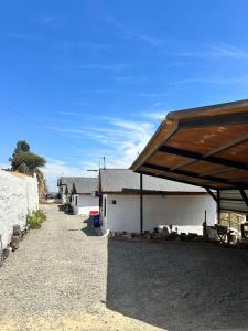 a building with a roof on the side of a road at Cabañas las Balsas Rapel in Las Cabras