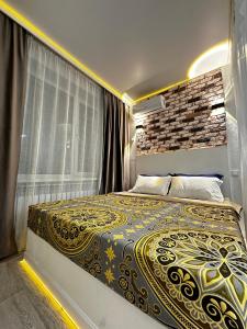 a bedroom with a bed with a large window at «Созвездие Auezov City: Уютные апартаменты в Сердце города» in Almaty