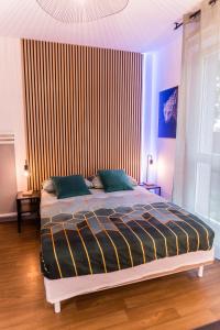 ein Schlafzimmer mit einem Bett mit gestreifter Wand in der Unterkunft Charmant studio avec Parking privé - Proche Part-Dieu in Villeurbanne