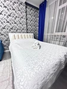 een slaapkamer met een bed met twee handdoeken erop bij Goktash in Bisjkek