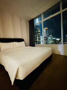 a large white bed in a room with a window at Vortex Suites KLCC By Paradise IN Kuallampur City in Kuala Lumpur