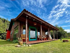 a cabin with a green door in the grass at Lagoa Country Club in Cidreira