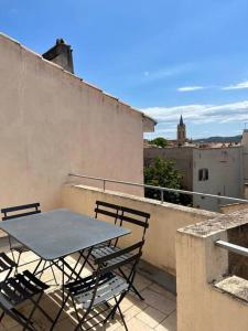 a table and chairs on top of a balcony at Appart. avec terrasse au cœur du centre historique in Aix-en-Provence