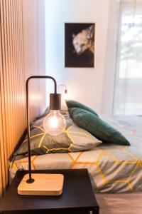 eine Lampe auf einem Tisch neben einem Bett in der Unterkunft Charmant studio avec Parking privé - Proche Part-Dieu in Villeurbanne