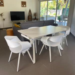 biały stół i krzesła w salonie w obiekcie magnifique villas capucines avec piscine w mieście Port-Louis
