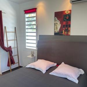 2 białe poduszki siedzące na łóżku w pokoju w obiekcie magnifique villas capucines avec piscine w mieście Port-Louis