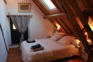 a bedroom with a white bed with a window at LA LONGERE GALOPE in Sainte-Gauburge-Sainte-Colombe
