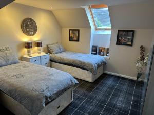 1 dormitorio con 2 camas y ventana en The Gables Whisky B&B, en Dufftown