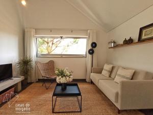 sala de estar con sofá y ventana en Casas do Morgadio, en Biscoitos